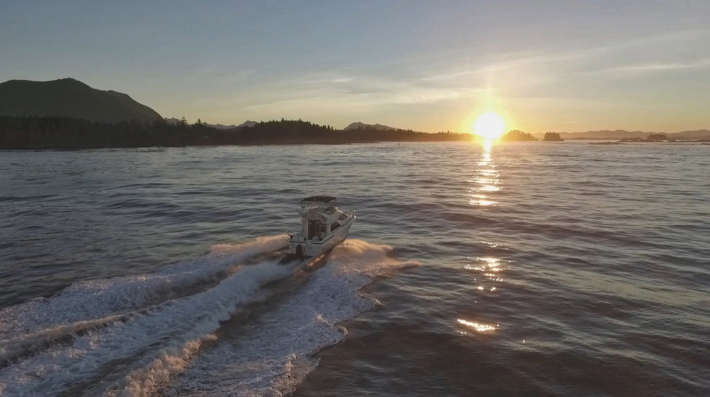 Picture of a fishing charter boat riding into the sunset