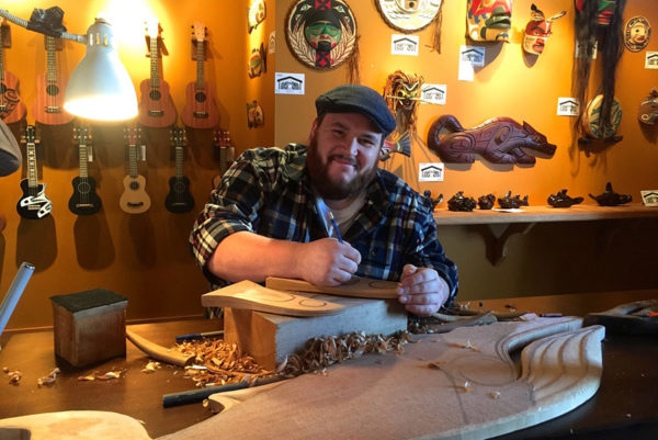 Man carving wood in a gallery