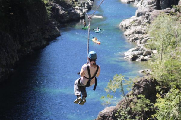 Image of someone ziplining through the rainforest